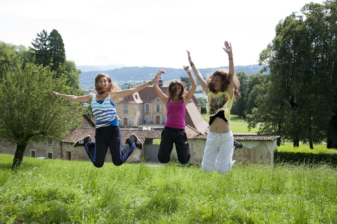 Jump young girls arms in the air in front of Longpra castle
